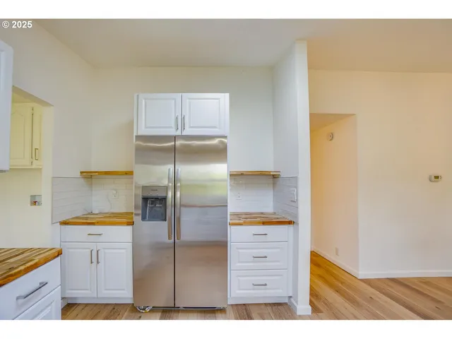 a kitchen with a sink refrigerator and cabinets