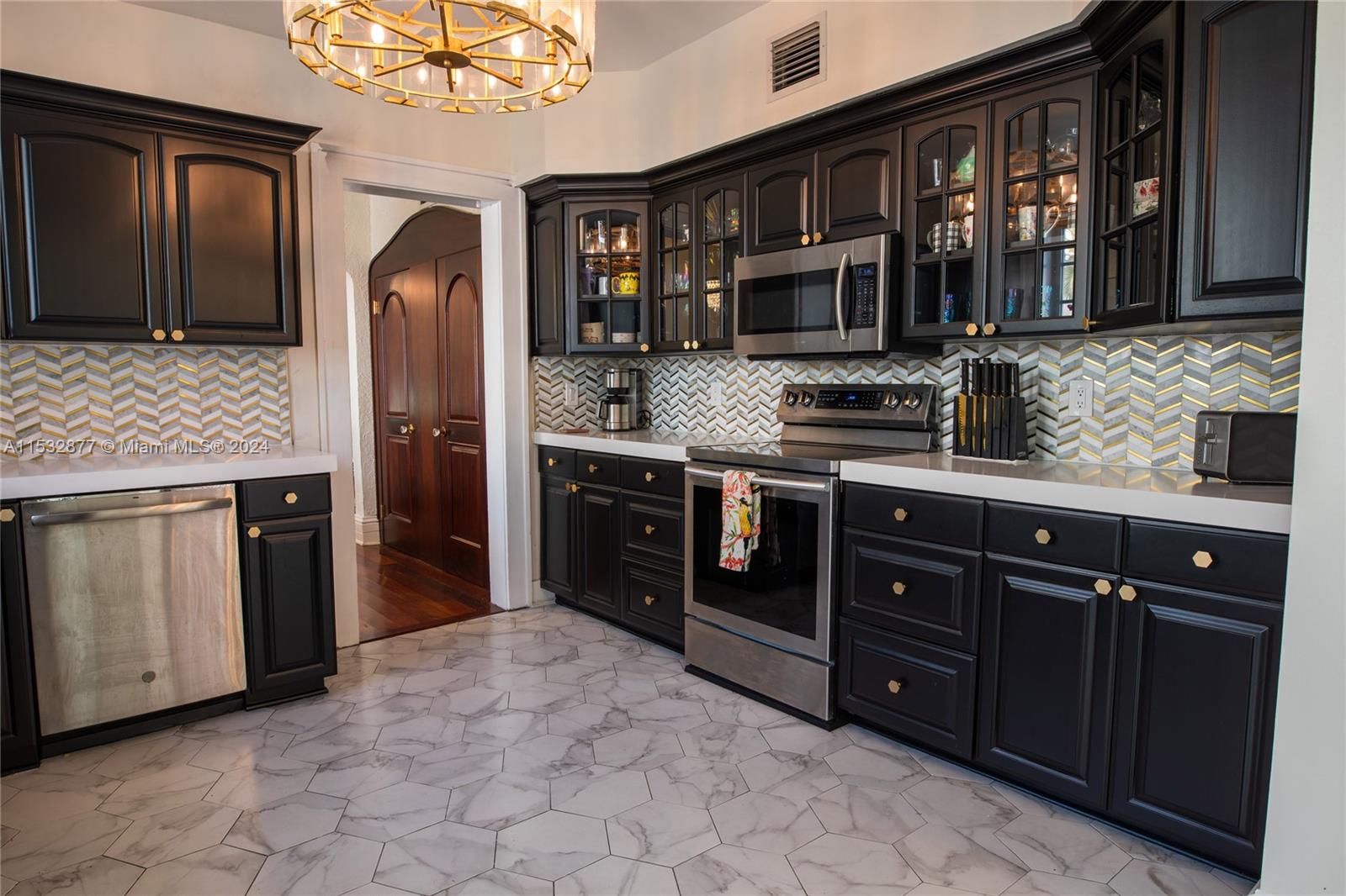 2112 Alton Road Miami Beach, FL 33140 - Photo 11 of 15 a kitchen with stainless steel appliances granite countertop a stove and a refrigerator
