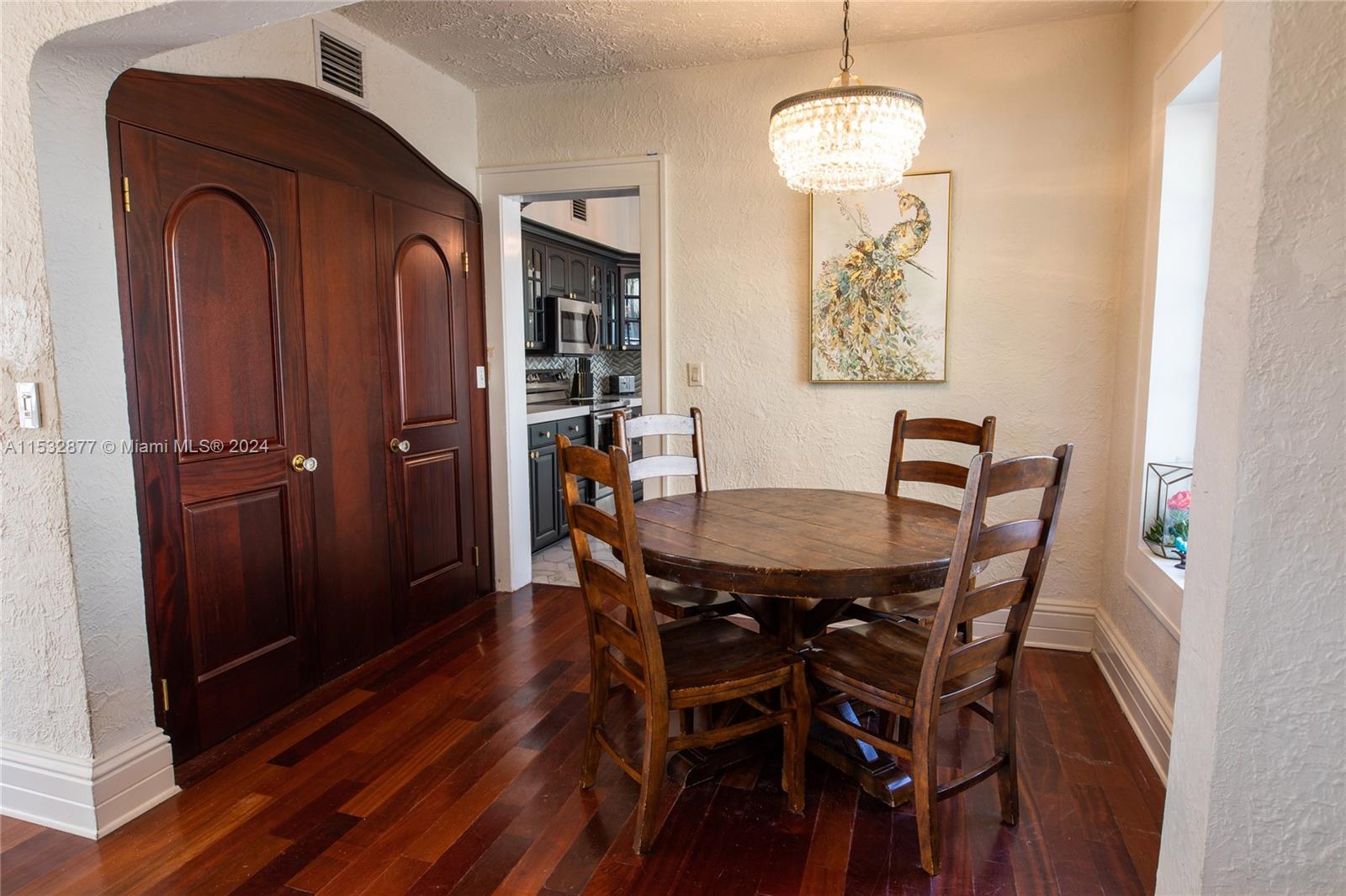 2112 Alton Road Miami Beach, FL 33140 - Photo 8 of 15 a view of a dining room with furniture wooden floor and a chandelier
