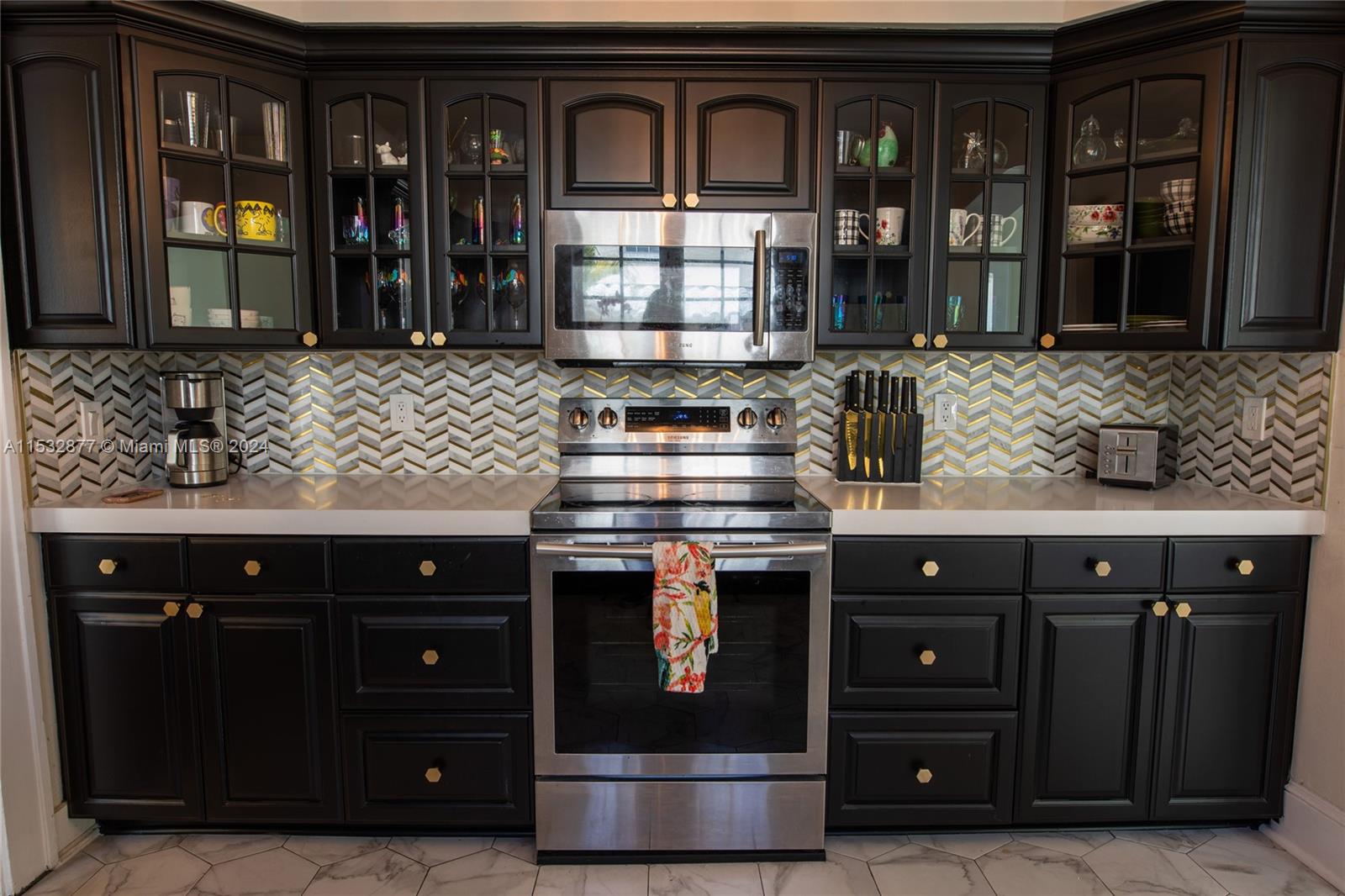 2112 Alton Road Miami Beach, FL 33140 - Photo 9 of 15 a kitchen with stainless steel appliances granite countertop a stove and a microwave