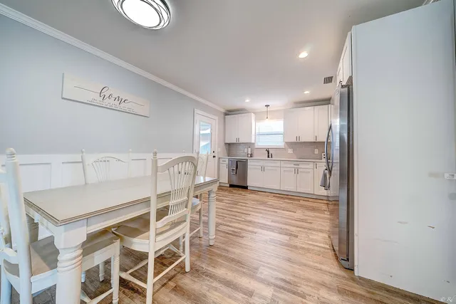 a kitchen with kitchen island wooden cabinets and refrigerator