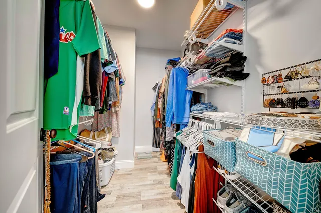 a view of walk in closet with clothes and shoes