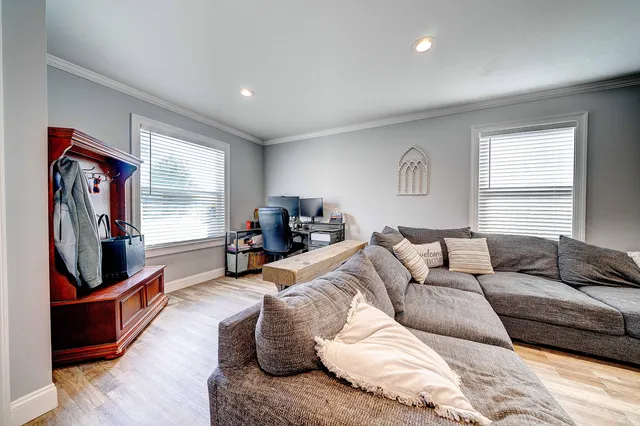 a living room with furniture flat screen tv and hard wood flooring