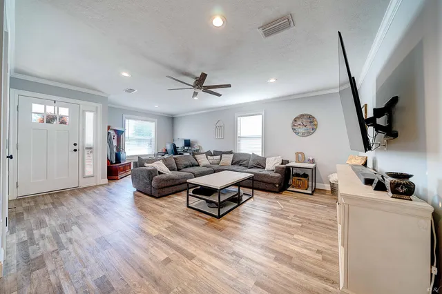 a living room with furniture and a wooden floor