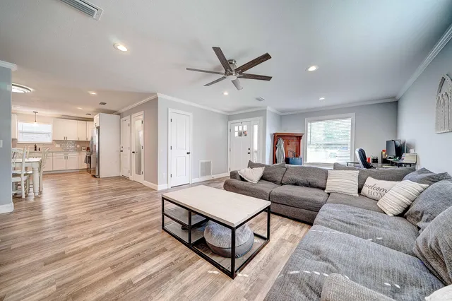 a living room with furniture and a wooden floor