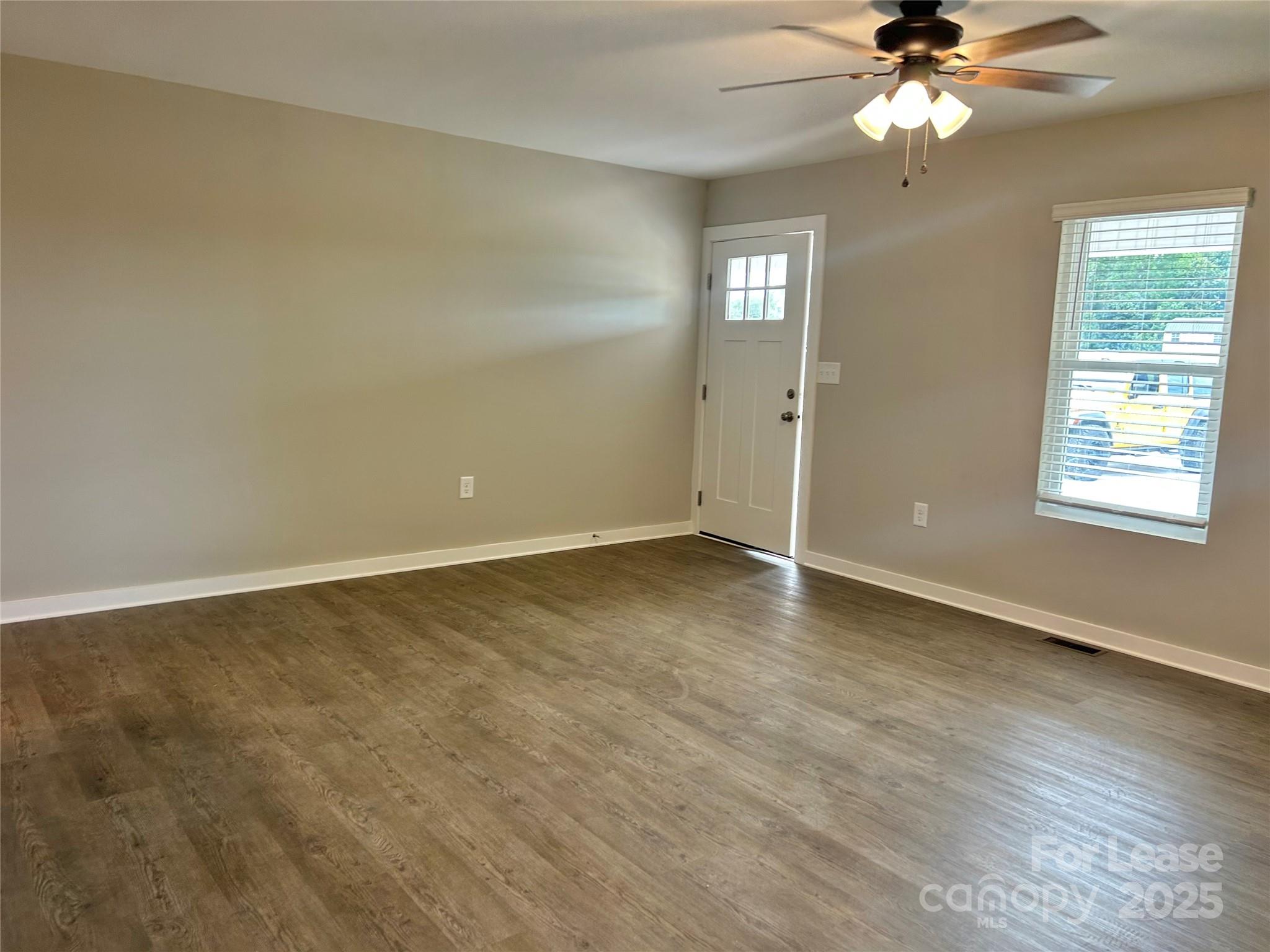 3291 Paul Elmore Road Lincolnton, NC 28092 - Photo 5 of 17 an empty room with wooden floor fan and windows