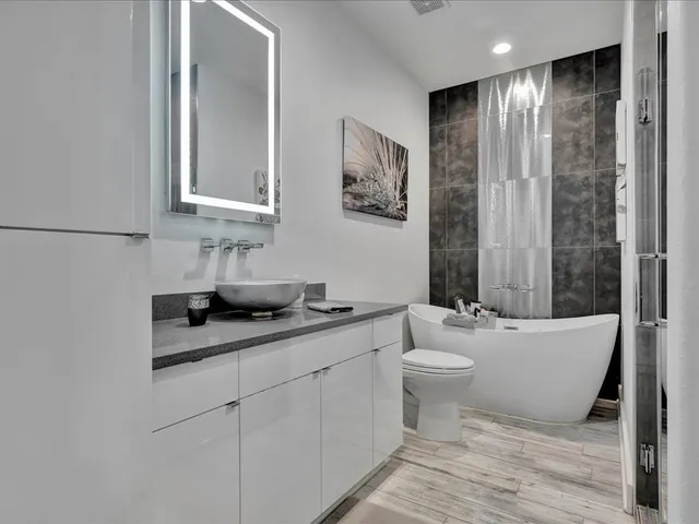 a bathroom with a granite countertop sink a toilet and shower