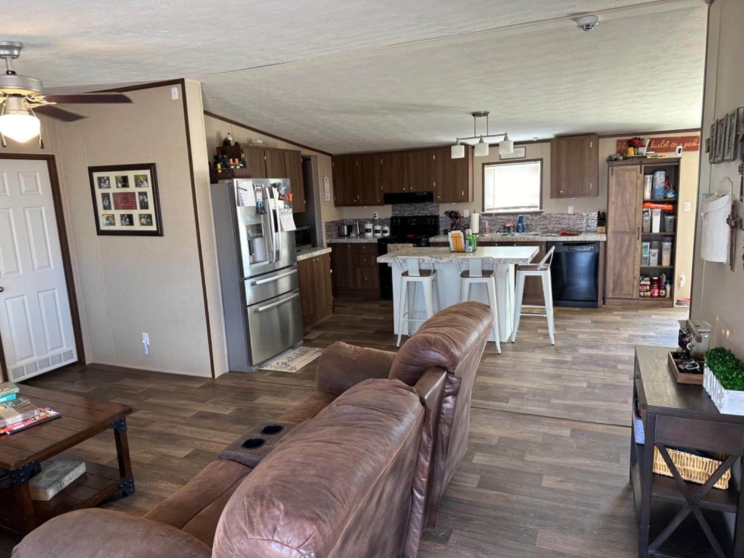 760 Highway 82 Ralls, TX 79357 - Photo 14 of 25 a living room with furniture a kitchen view and a refrigerator