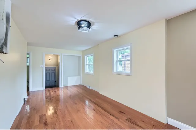 a view of a big room with wooden floor and windows