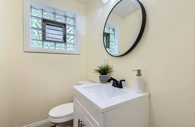 a bathroom with a toilet a sink and a mirror