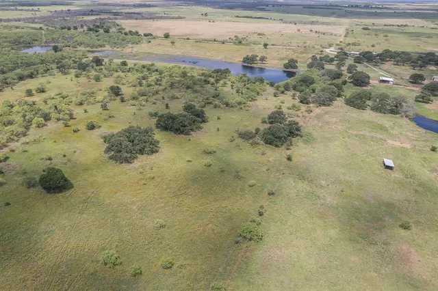 an aerial view of a house with a yard and lake view