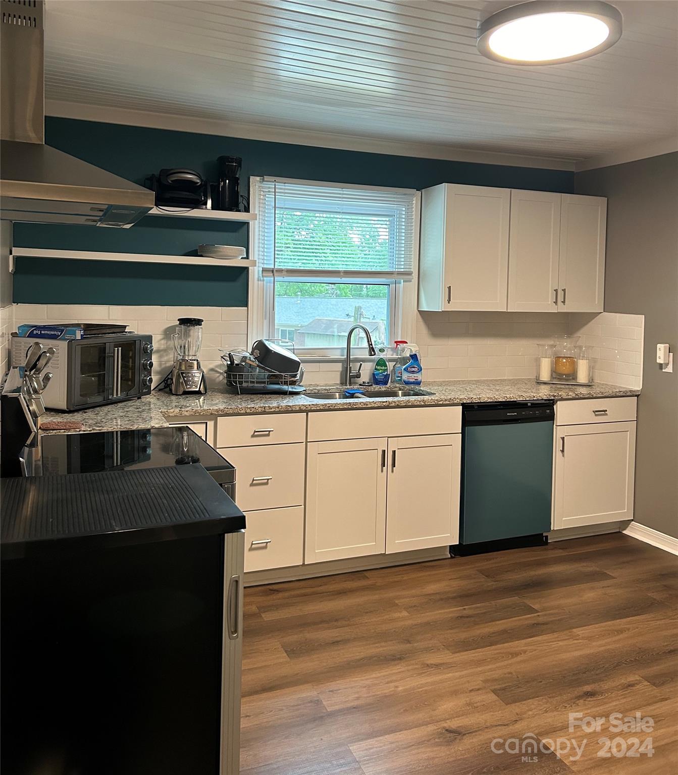 710 Union Cemetery Road Southwest Concord, NC 28027 - Photo 8 of 30 a kitchen with stainless steel appliances granite countertop a sink a stove and a wooden floors