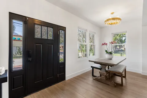 a living room with furniture potted plant and kitchen view