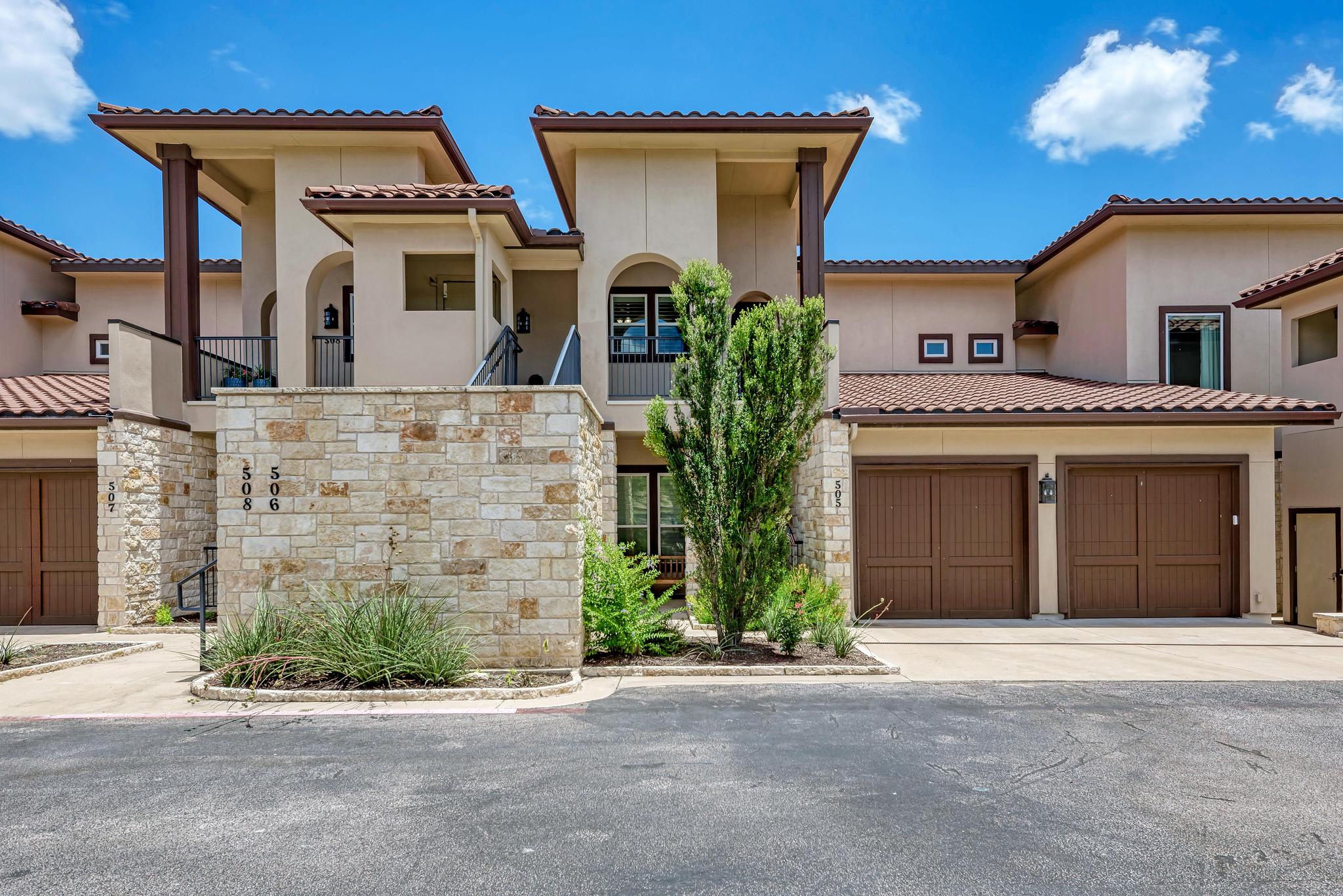 2601 North Quinlan Park Road, Unit 506 Austin, TX 78732 - Photo 1 of 39 A contemporary multi-level facade features stone accents, multiple garages, and an inviting entry framed by mature landscaping.