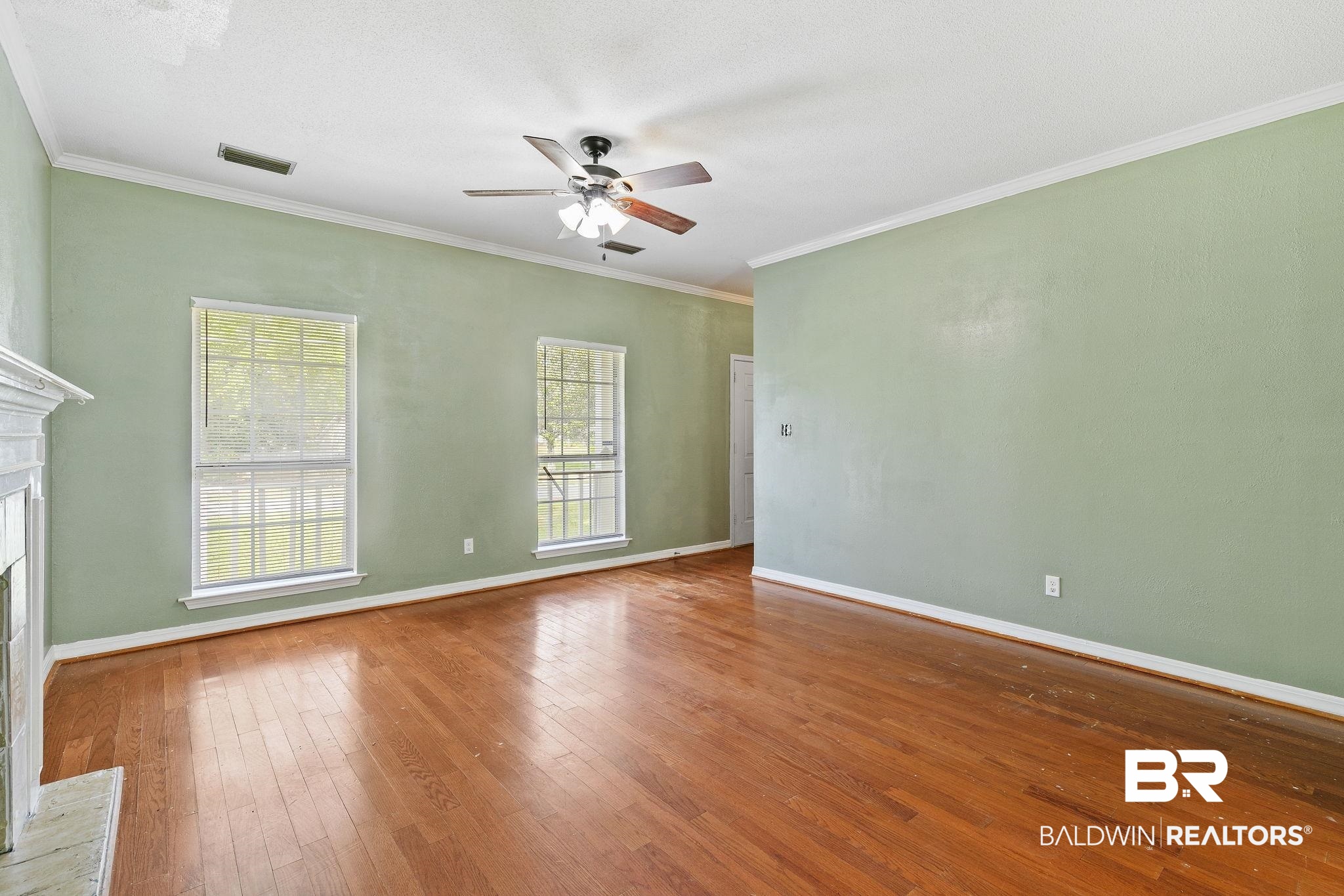 474 Ridgewood Drive Daphne, AL 36526 - Photo 14 of 57 Unfurnished living room with ornamental molding, hardwood / wood-style flooring, and ceiling fan