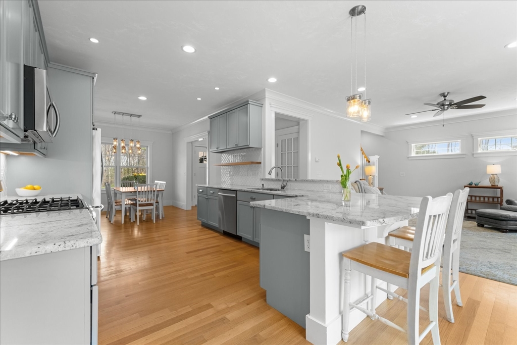 50 Quabbin Path Sutton, MA 01590 - Photo 17 of 42 a kitchen with stainless steel appliances granite countertop dining table chairs stove and white cabinets
