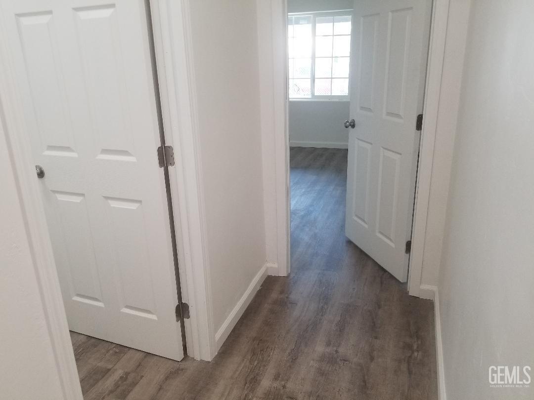 Undisclosed Address Delano, CA 93215 - Photo 6 of 10 a view of an empty room with wooden floor and a window