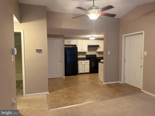 a view of a kitchen with a refrigerator and a chandelier