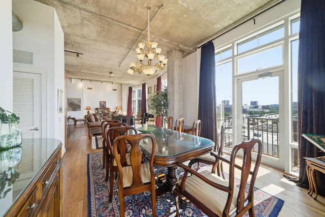 a dining room with furniture a chandelier and wooden floor