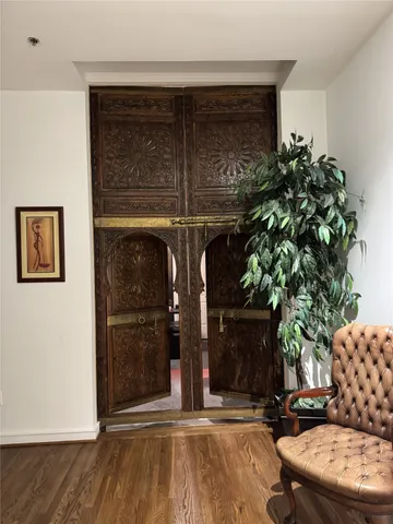 a room with wooden floor and a potted plant