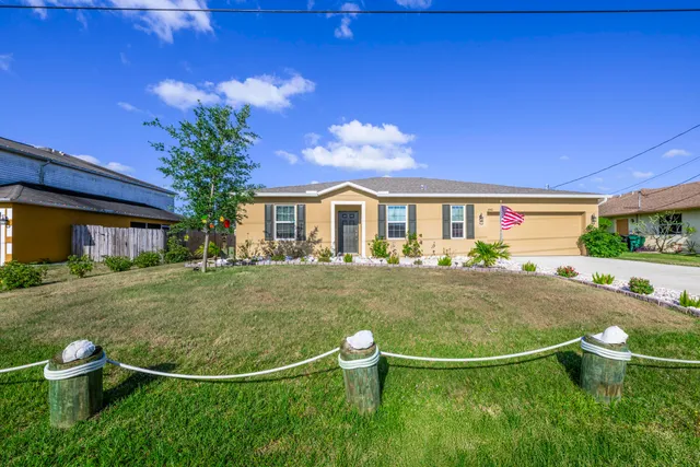 a view of a white house with a swimming pool and a yard