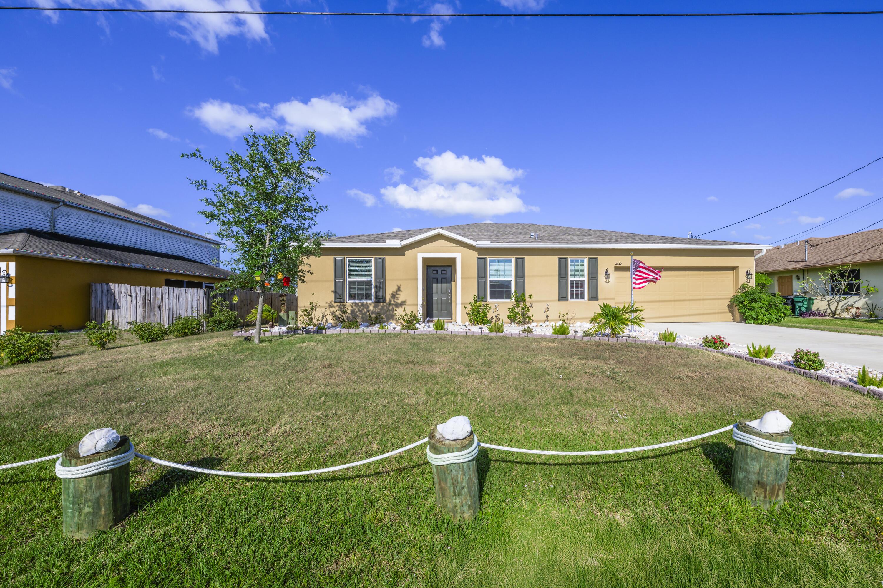 a view of a white house with a swimming pool and a yard