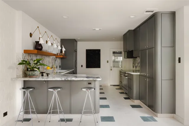 a kitchen with stainless steel appliances kitchen island granite countertop a refrigerator and a stove