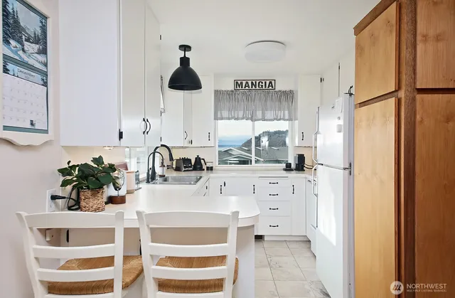 a kitchen with stainless steel appliances a sink a refrigerator and cabinets