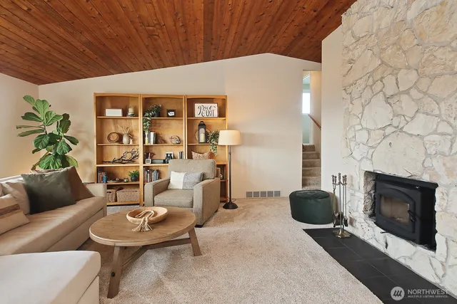 a living room with furniture a fireplace and a potted plant