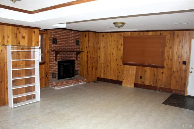 an empty room with a fireplace and cabinet