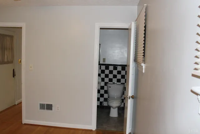 a bathroom with a toilet and a shower curtain