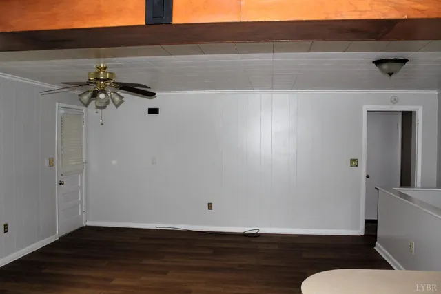 a view of a livingroom with wooden floor and a ceiling fan