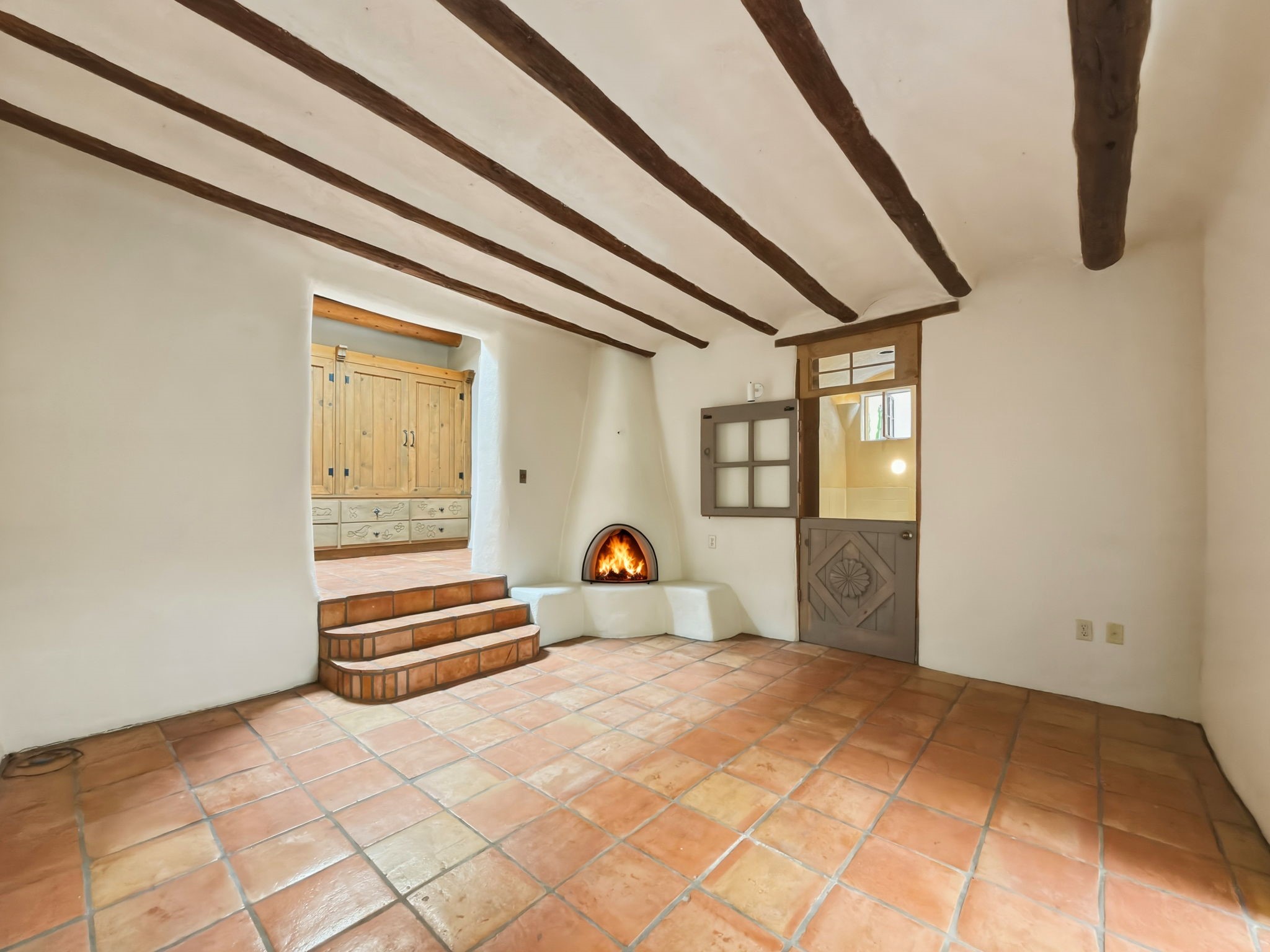 1692 Upper Canyon Road Santa Fe, NM 87501 - Photo 9 of 52 Spacious Primary suite with a kiva wood-burning fireplace and generous wardrobe space.