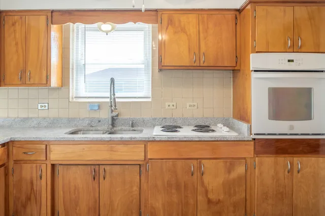a kitchen with stainless steel appliances granite countertop a sink and a white cabinets