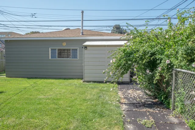a view of a brick house with a yard and plants