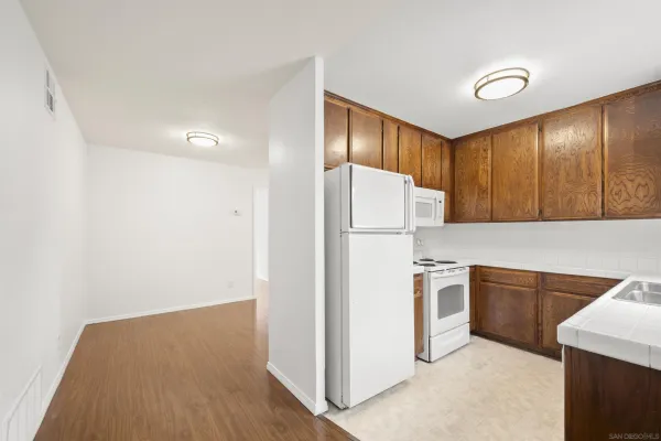 a kitchen with cabinets a refrigerator and a sink