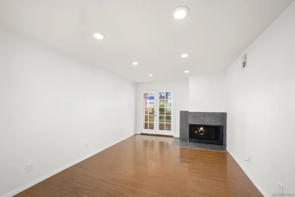 an empty room with fireplace and a window