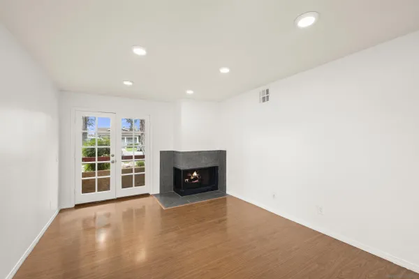 an empty room with a fireplace and window
