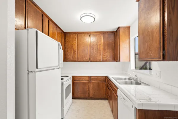 a kitchen with a sink a refrigerator and cabinets