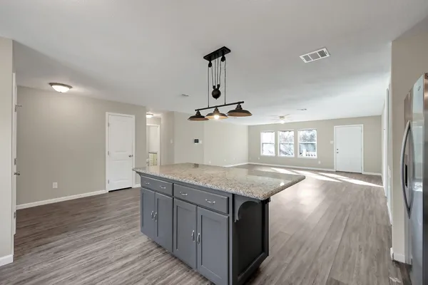 a kitchen with granite countertop a stove and wooden floor