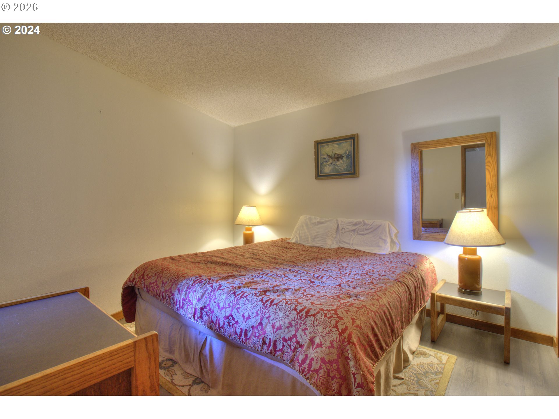 94304 Wedderburn Loop, Unit 419 Gold Beach, OR 97444 - Photo 10 of 23 a bedroom with a bed and a lamp