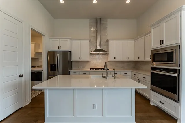 a kitchen with a sink a microwave a refrigerator and cabinets