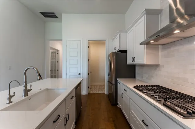 a kitchen with stainless steel appliances a sink a stove and cabinets