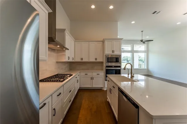 a kitchen with stainless steel appliances granite countertop a sink stove and refrigerator