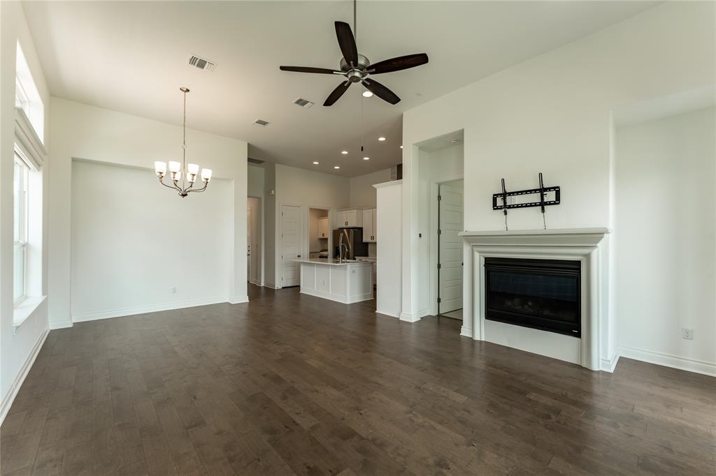 152 Limestone Drive Georgetown, TX 78628 - Photo 20 of 36 an empty room with wooden floor a ceiling fan and a fireplace