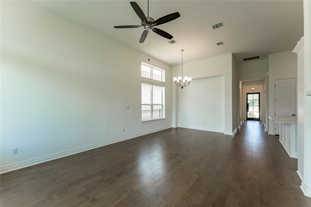 152 Limestone Drive Georgetown, TX 78628 - Photo 21 of 36 an empty room with wooden floor ceiling fan and windows
