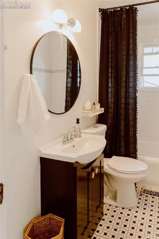 a bathroom with a sink a toilet and a mirror