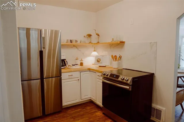 a kitchen with a refrigerator and a stove