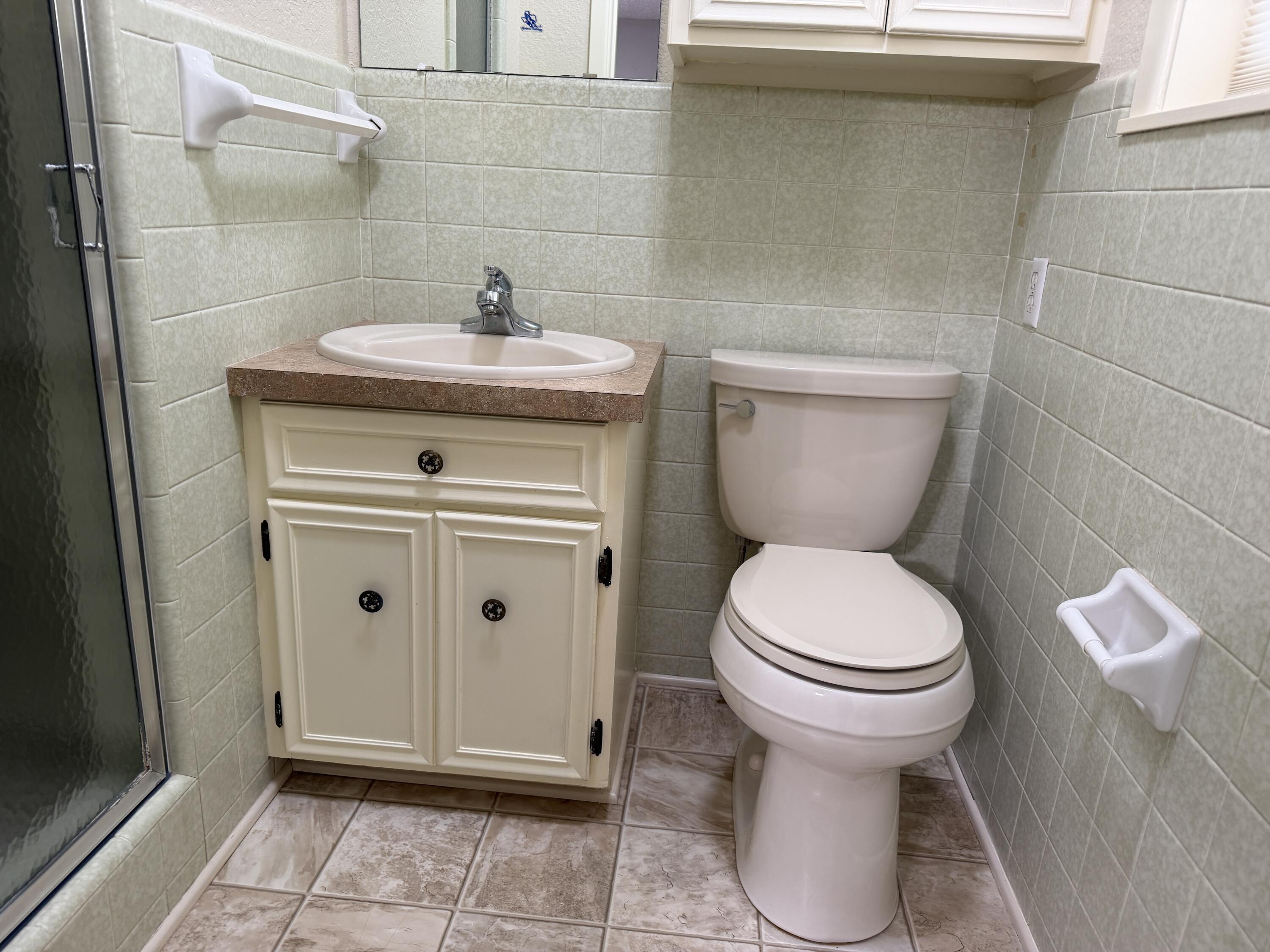 1603 South 8th Street Lamesa, TX 79331 - Photo 18 of 39 a bathroom with a toilet sink and mirror