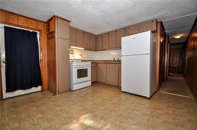 a view of a storage & utility room with a fridge